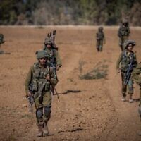 Israeli soldiers from the Netzah Yehuda Battalion patrol near the Israeli-Gaza border, October 20, 2023. (The Times of Israel: Yonatan Sindel/ Flash90)