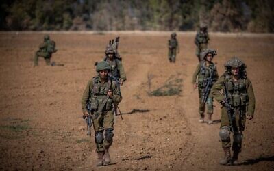 Israeli soldiers from the Netzah Yehuda Battalion patrol near the Israeli-Gaza border, October 20, 2023. (The Times of Israel: Yonatan Sindel/ Flash90)