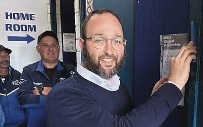 Rabbi Rabin attaches the mezuzah at MFCC's renovated change rooms.