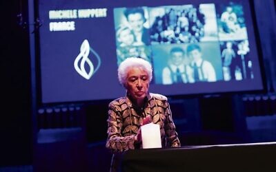Michele Huppert lights a candle. Photo: Peter Haskin