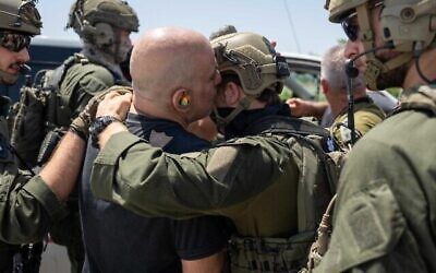 Shlomi Ziv embraces a soldier as he lands in Israel after being rescued from Hamas captivity, June 8, 2024. (The Times of Israel: IDF Spokesperson’s Unit)