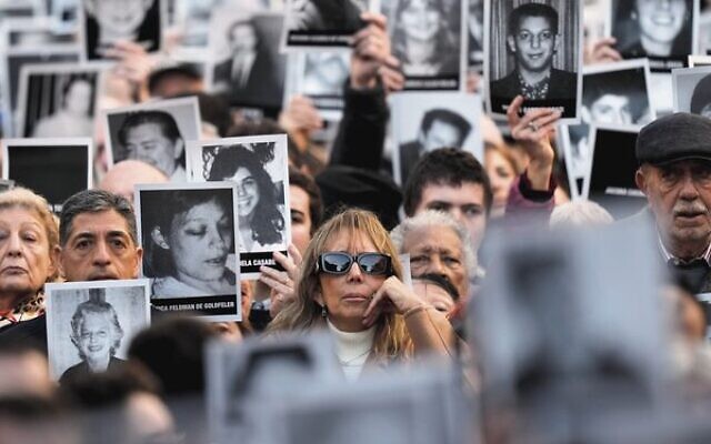 People hold photos of bombing victims as sirens blare during a ceremony last Thursday marking the 30th anniversary of the bombing of the AMIA Jewish centre that killed 85 people in Buenos Aires. Photo: AP/Natacha Pisarenko