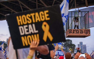 Demonstrators protest for the release of hostages in the Gaza Strip, outside the Kirya military headquarters in Tel Aviv, July 7, 2024. Einav Zangauker, the mother of hostage Matan Zangauker, is standing in the cage at left. The slogan on the cage reads, "Netanyahu, it's in your hands." (The Times of Israel: Itai Ron/ Flash90)