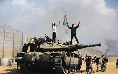 Gazans celebrate by a destroyed Israeli tank on October 7. 
Photo: AP/Yousef Masoud
