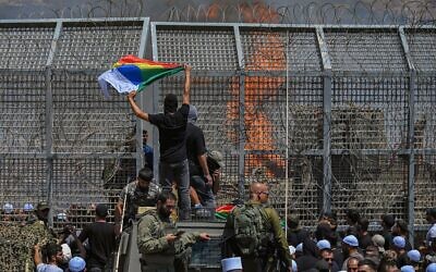 Druze residents protest near the Israeli-Syrian border fence in solidarity with their community in Syria, in Majdal Shams, July 16, 2025. (Michael Giladi/Flash90)