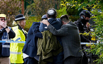 Members of the Jewish community comfort each other near the Heaton Park Hebrew Congregation synagogue, in Crumpsall, Manchester. Photo: Peter Byrne/PA via AP