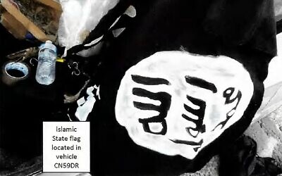 This handout photo from a court exhibit released by the NSW Courts as part of the police fact sheet on December 22, 2025, shows a general view of a home-made painted Islamic State (ISIS) flag, appearing to be made with white paint on black fabric, located in the vehicle CN59DR, registered to Naveed Akram, in Sydney. (Handout / NSW Courts / AFP)