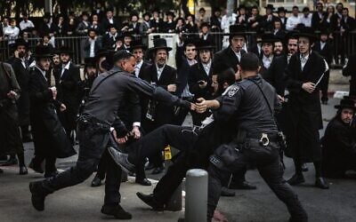 Police detain an ultra-Orthodox man during a protest against Charedi enlistment outside a military recruitment center in Jerusalem, November 12, 2025. Photo: Chaim Goldberg/Flash90