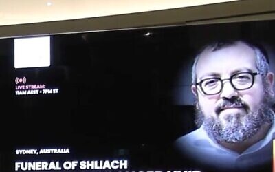An image of Rabbi Eli Schlanger is displayed on a big screen at his funeral service at Chabad of Bondi shule on December 17.