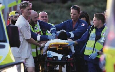 A person is aided by paramedics after the shooting at a Chanukah event at Bondi Beach. Photo: AP Photo/Mark Baker