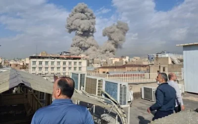 People watch as smoke rises on the horizon after an explosion in Tehran, Iran, February 28, 2026. (AP Photo)