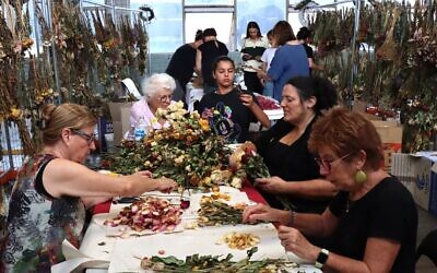 Volunteers sort through flowers left in tribute at Bondi Pavilion for preservation by the Sydney Jewish Museum. Photo: Supplied
