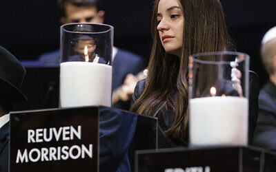 Sheina Gutnick lights a candle at the Sydney Opera House vigil on January 22 in honour of her father Reuven Morrison. Photo: Facebook