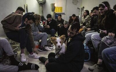 Israelis take cover in a public shelter in Tel Aviv as a siren sounds warning of incoming ballistic missiles from Iran. Photo: Chaim Goldberg/Flash90