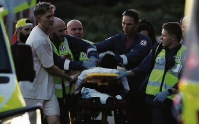 A person is aided by paramedics after the shooting at a Chanukah event at Bondi Beach. Photo: AP Photo/Mark Baker