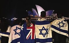 Australian Jews stand across form the Opera House as it is lit blue and white on October 9, 2023.