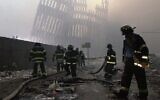 Firefighters work beneath the destroyed vertical struts that once faced the outer walls of the World Trade Centre towers. 
Photo: AP Photo/Mark Lennihan, File