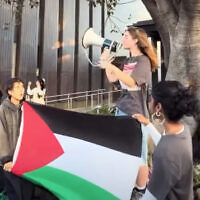 A students activist speaks in a megaphone while others hold a Palestinian flag. Photo: Instagram screenshot