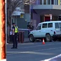 This frame grab taken from video footage provided by the Australian Broadcasting Corporation (ABC) on October 19, 2026 via AFPTV shows police officers at the scene after Australian independent lawmaker Helen Haines was struck by a car and suffered critical injuries outside her office in Wangaratta, about 200 kilometers northeast of Melbourne. (AFP/AUSTRALIAN BROADCASTING CORPORATION)