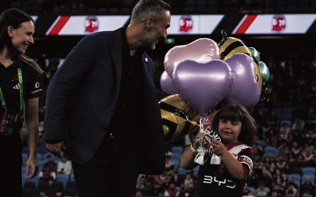 Alex Ryvchin and Summer Britvan on the field before the Sydney Roosters season opener in March.