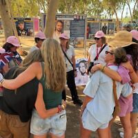 The ORAH Sydney group comfort each other after scattering sand from Bondi at the Nova Music Festival site. Photo: supplied
