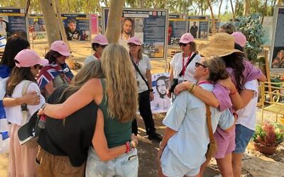 The ORAH Sydney group comfort each other after scattering sand from Bondi at the Nova Music Festival site. Photo: supplied