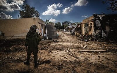 An IDF soldier stands amid destruction caused by Hamas terrorists in Kibbutz Kfar Aza, October 15, 2023. Photo: Chaim Goldberg/Flash90