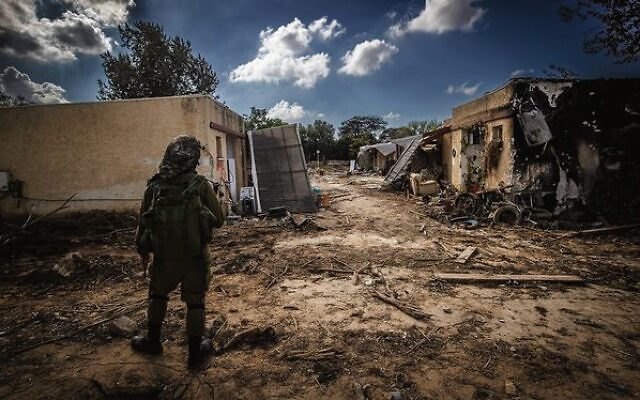 An IDF soldier stands amid destruction caused by Hamas terrorists in Kibbutz Kfar Aza, October 15, 2023. Photo: Chaim Goldberg/Flash90
