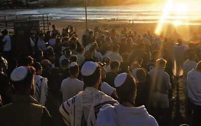 People gather at sunrise on Bondi Beach to pray in support of Israel and the hostages who were kidnapped by Hamas. Photo: Jeremy Piper/State Library of NSW