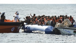توضيحية: مهاجرون ولاجئون يجلسون في قارب مطاطي خلال عملية إنقاذ ل’توباز رسبوندر’، قارب إنقاذ تديره منظمة Moas غير الحكومية المالطية والصليب الأحمر الإيطالي بمساعدة خفر الساحل الليبي قبالة السواحل الليبية، 4 نوفمبر، 2016.  (AFP PHOTO / ANDREAS SOLARO)