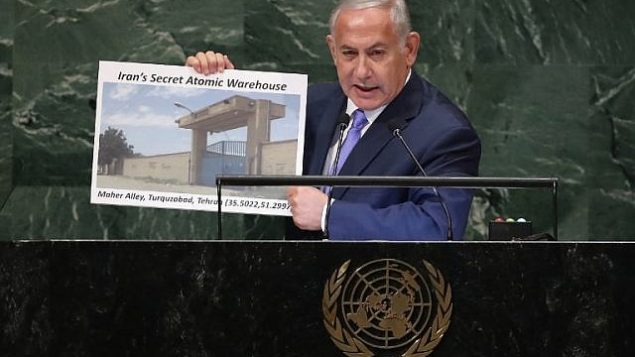 رئيس الوزراء الإسرائيلي بنيامين نتنياهو يحمل لافتة تظهر موقعاً إيرانياً مشكوكاً فيه، خلال إلقائه لخطاب في الجمعية العامة للأمم المتحدة في 27 أيلول / سبتمبر 2018 في مدينة نيويورك. (John Moore/Getty Images/AFP)