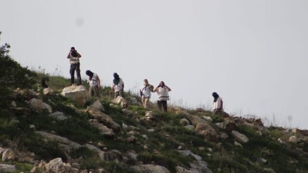مستوطنون من حومش يرسقون الحجارة على الفلسطينيين، في 26 مارس 2020. (Yesh Din)