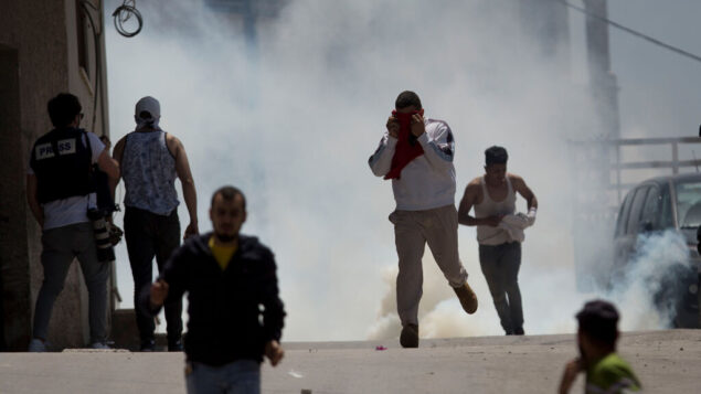 فلسطينيون يهربون من الغاز المسيل للدموع الذي أطلقه جنود إسرائيليون خلال اشتباكات في قرية يعبد في الضفة الغربية، 12 مايو 2020. (AP / Majdi Mohammed)