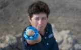 عالمة الآثار في سلطة الآثار الإسرائيلية آلا ناغورسكي مع بيضة عمرها 1000 عام تم اكتشافها في يافني.  (Yoli Schwartz/Israel Antiquities Authority)