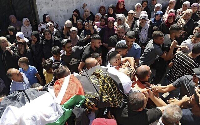 مشيعون يحملون جثمان اسامة صبح عضو حركة الجهاد الاسلامي الفلسطيني الذي قُتل برصاص جنود اسرائيليين خلال معركة مسلحة بالقرب من جنين، خلال جنازته في قرية برقين شمال الضفة الغربية، 26 سبتمبر، 2021 (JAAFAR ASHTIYEH / AFP)