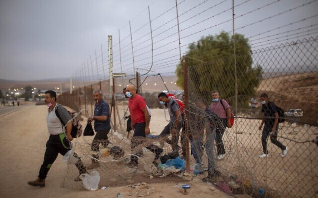 عمال من السلطة الفلسطينية يمرون عبر خرق في السياج الحدودي بالقرب من الخليل، 6 سبتمبر، 2020 (الصورة: AP Photo / Oded Balilty)
