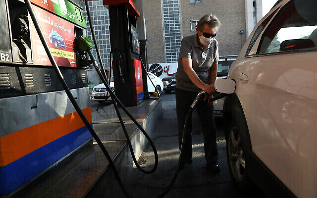 رجل يملأ سيارته بالوقود في محطة وقود وسط هجوم إلكتروني على نظام الوقود في البلاد، في طهران، إيران، 27 أكتوبر، 2021. (AP Photo / Vahid Salemi)