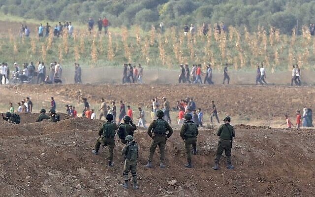 جنود إسرائيليون يتخذون مواقعهم خلال مواجهات مع متظاهرين فلسطينيين عبر حدود غزة في 19 أكتوبر، 2018 بالقرب من ناحال عوز. (جاك جويز / وكالة الصحافة الفرنسية)