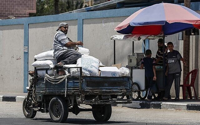 فلسطيني يركب شاحنة صغيرة محملة بأكياس مساعدات غذائية تقدمها وكالة الامم المتحدة لإغاثة وتشغيل اللاجئين الفلسطينيين (أونروا) في مدينة رفح جنوب غزة، 25 يونيو 2019 (Said Khatib / AFP)