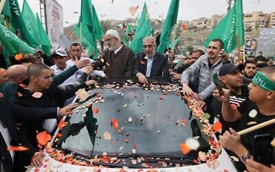 الشيخ رائد صراح (وسط الصورة من اليسار)، زعيم الفرع الشمالي للحركة الإسلامية في إسرائيل، يحتفل مع أنصاره في مدينة أم الفحم العربية في شمال إسرائي بعد إطلاق سراحه من السجن، 13 ديسمبر، 2021. (AHMAD GHARABLI / AFP)