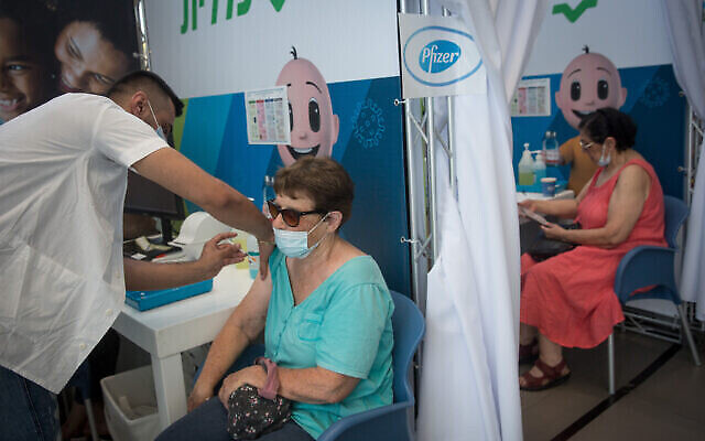صورة توضيحية: إسرائيليون ما فوق 60 عاما يتلقون جرعتهم الثالثة من لقاح كورونا في مركز الرعاية الصحية المؤقت كلاليت في تل أبيب، 10 أغسطس، 2021 (Miriam Alster / Flash90)
