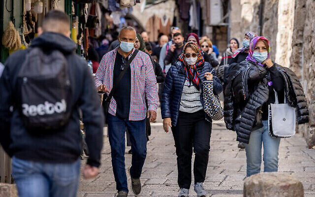 أشخاص يسيرون في البلدة القديمة في القدس، 5 ديسمبر 2021 (Yonatan Sindel / Flash90)