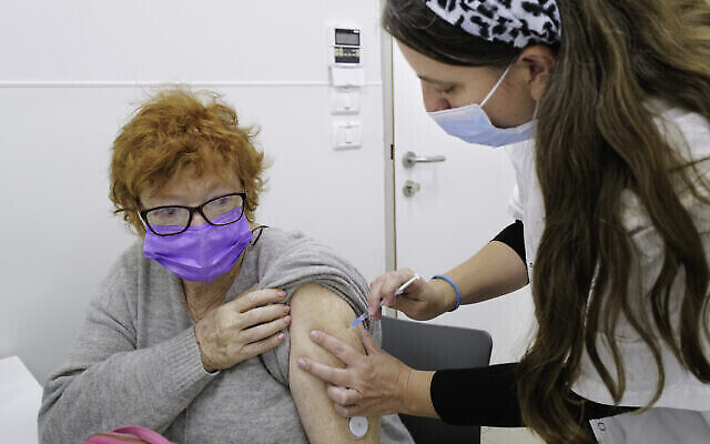 سيدة إسرائيليون تتلقى جرعة من لقاح كوفيد-19 في مركز صحي في كتسرين، مرتفعات الجولان، 12 ديسمبر، 2021. (Michael Giladi / Flash90)
