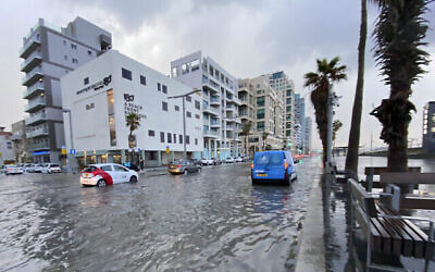 إسرائيليون يقودون سياراتهم في شارع غمرته المياه بسبب الأمطار الغزيرة في تل أبيب، 21 ديسمبر 2021 (Avshalom Sassoni / Flash90)