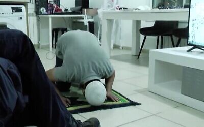 لقطة شاشة من مقطع فيديو لمدرب من مجموعة "العودة إلى الهيكل" يوضح للأعضاء كيفية الصلاة مثل المسلمين أثناء تلاوة الصلوات اليهودية. (أخبار القناة 13)