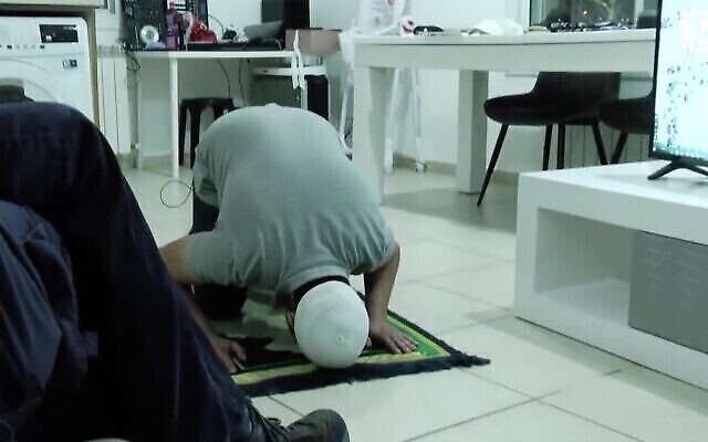 لقطة شاشة من مقطع فيديو لمدرب من مجموعة "العودة إلى الهيكل" يوضح للأعضاء كيفية الصلاة مثل المسلمين أثناء تلاوة الصلوات اليهودية. (أخبار القناة 13)