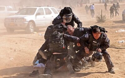 الشرطة الإسرائيلية تعتقل رجلا بدويا خلال تظاهرة في النقب بجنوب البلااد ضد مشروع تشجير للصندوق القومي اليهودي، 12 يناير، 2022. (AHMAD GHARABLI / AFP)