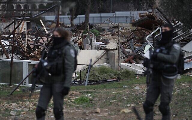القوات الإسرائيلية تقف بجانب أنقاض منزل فلسطيني هدمته السلطات في حي الشيخ جراح في القدس، 19 يناير، 2022. (Ahmad Gharabli/AFP)