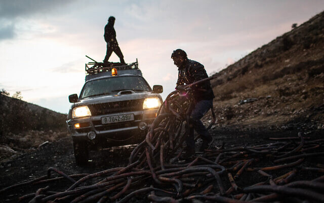 فلسطيني يجمع كابلات نحاسية من موقع نفايات بالقرب من بيت عوا. (Tamir Kalifa)