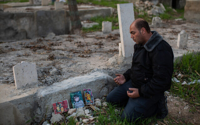فلسطيني يزور قبر أبنائه الثلاثة في بيت عوا. يقدر الأطباء أنهم ماتوا بسبب تلوث الهواء.  (Tamir Kalifa)